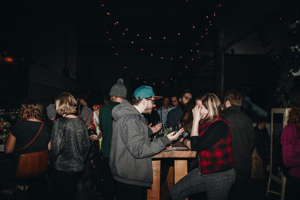 A group of people standing around a wooden table